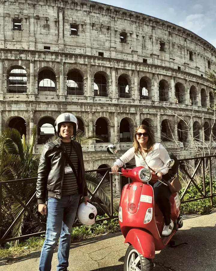 A guest on a red Vespa with the guide at the Colosseum
