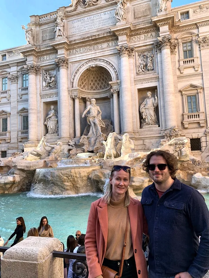 A couple posing at the Trevi Fountain