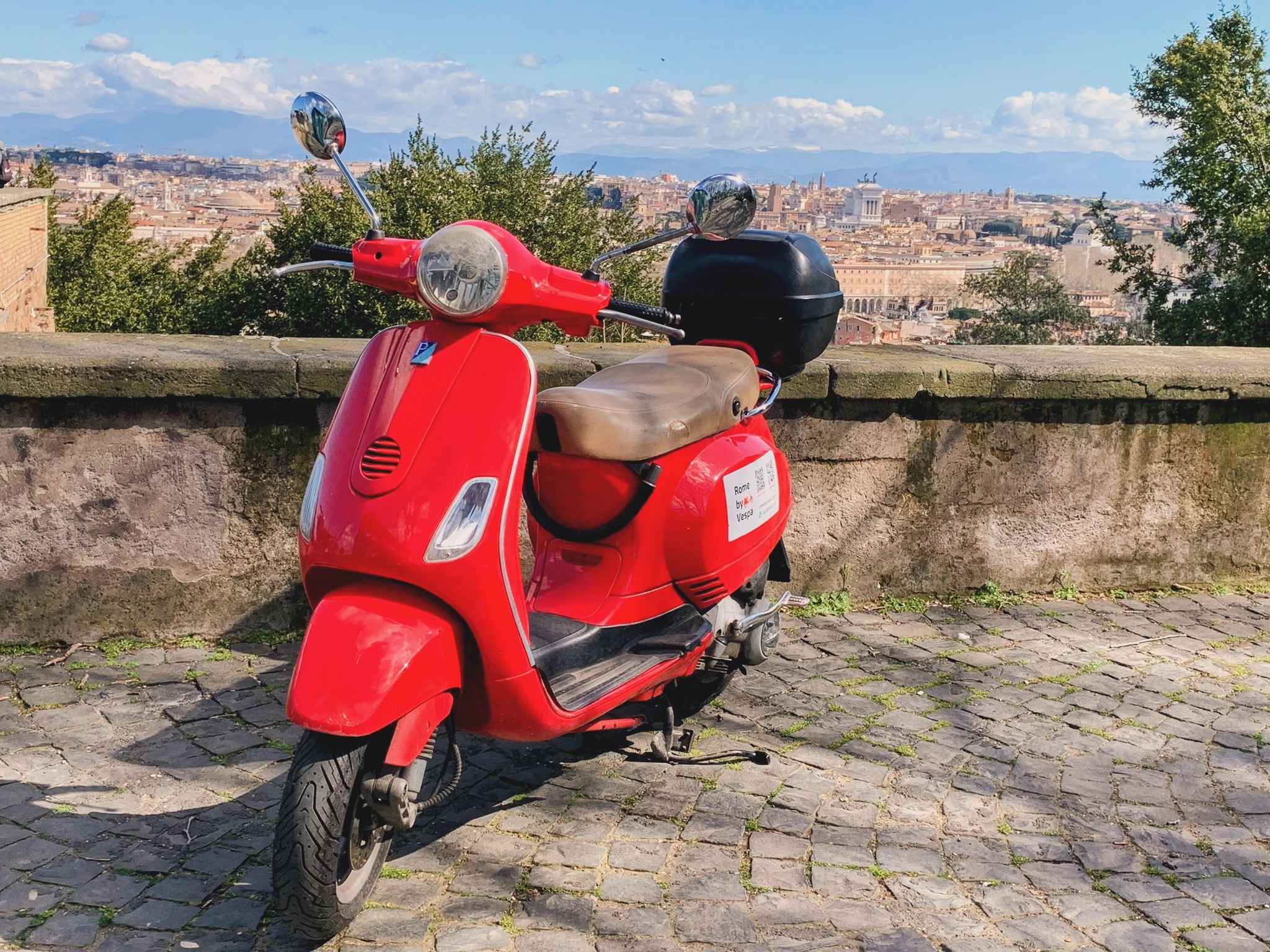 A Vespa parked in a Roman street at golden hour